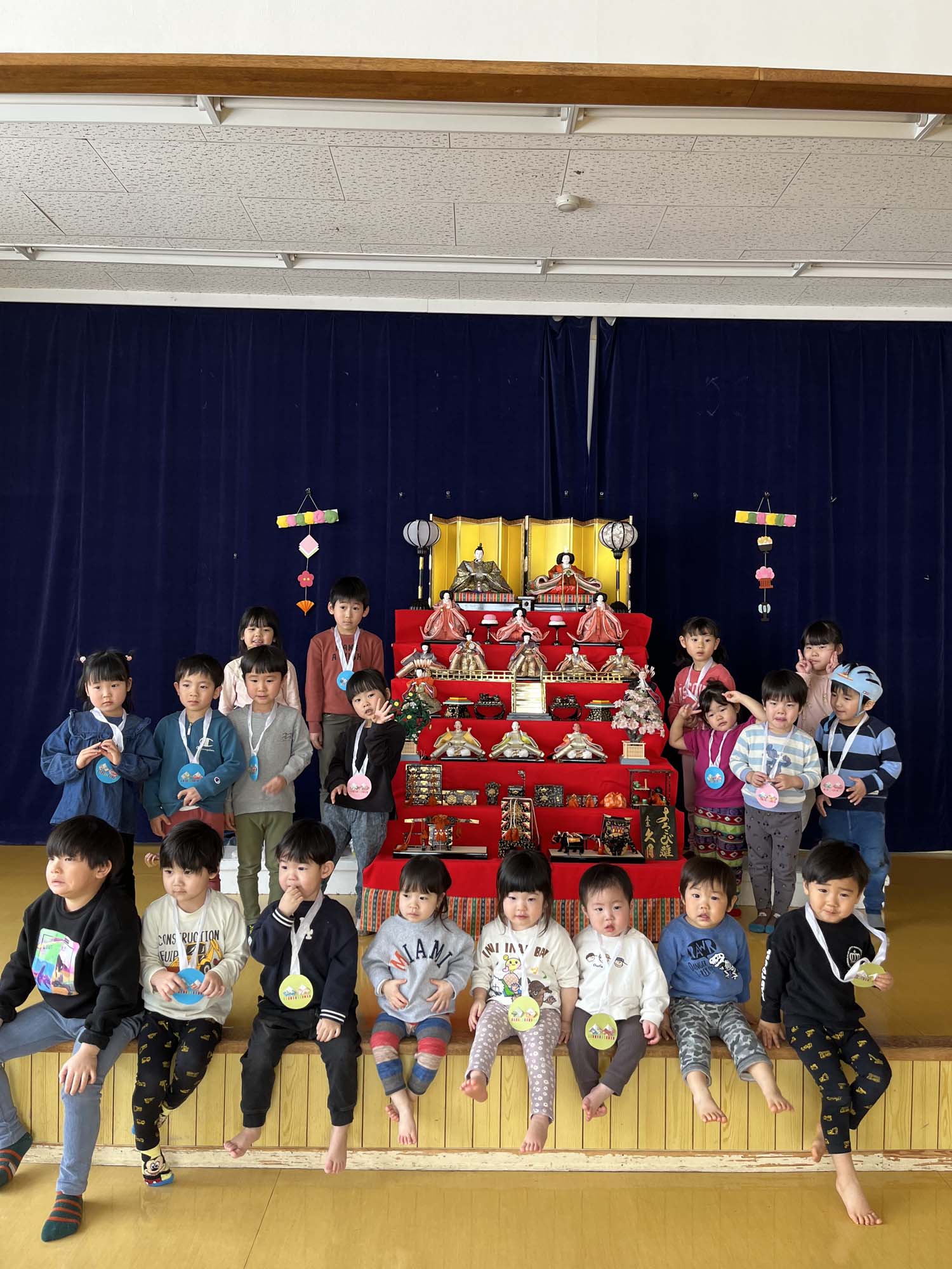 ひな壇飾りを前に記念撮影