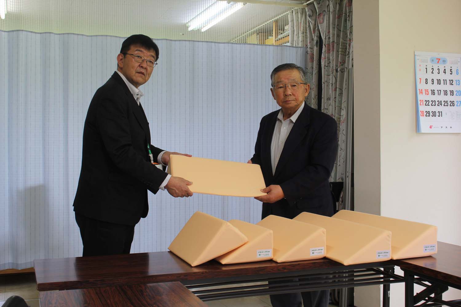 日高信用金庫 (大沼孝司理事長)より浦河向陽園 (三好吉男理事長)へ介護用のクッション3種類2セットが寄贈される様子