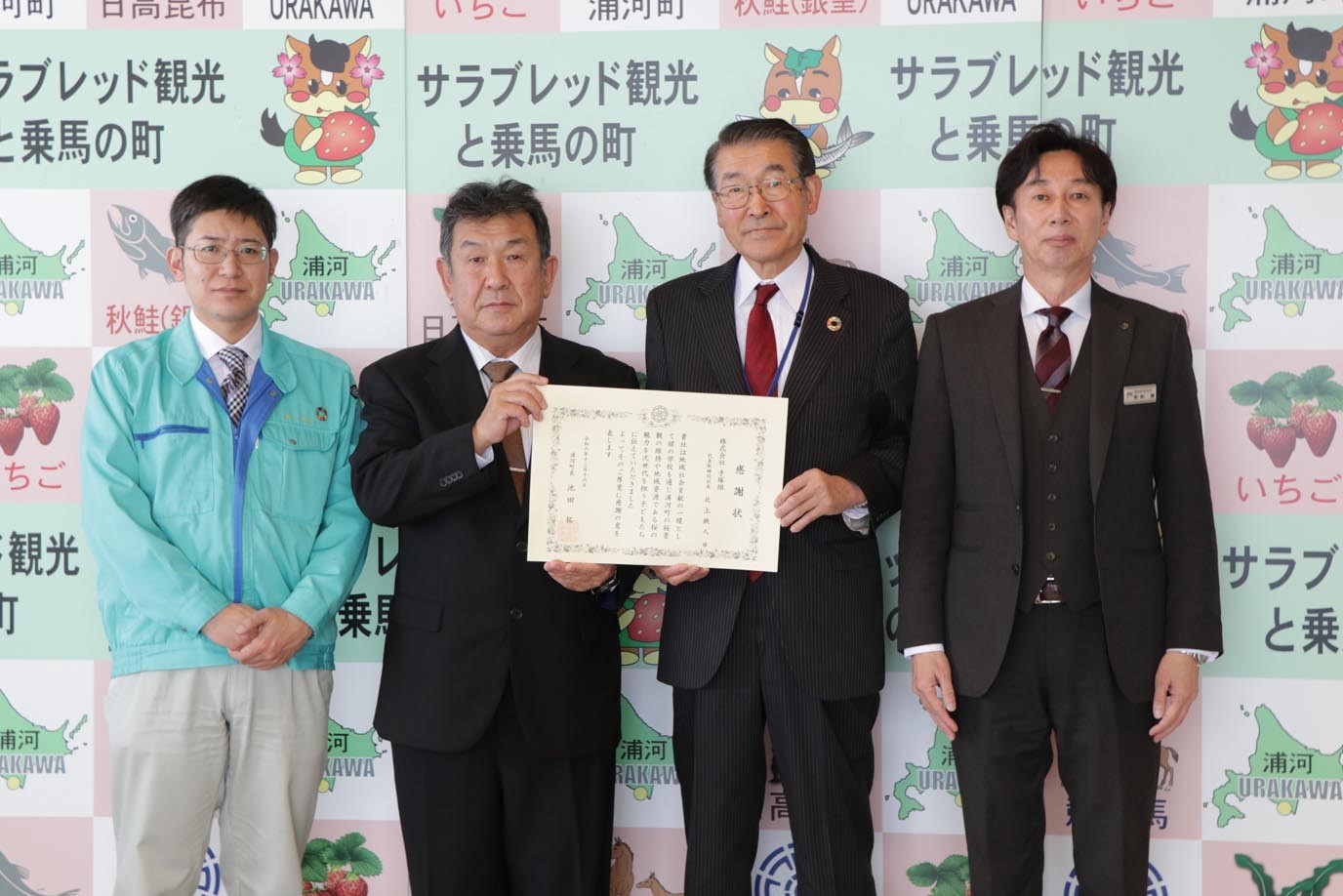 株式会社手塚組(北上鉄人代表取締役社長)へ町長より感謝状が手渡される様子